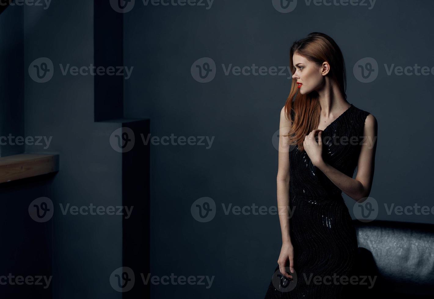 Portrait of elegant lady in black dress in gray room cropped view photo
