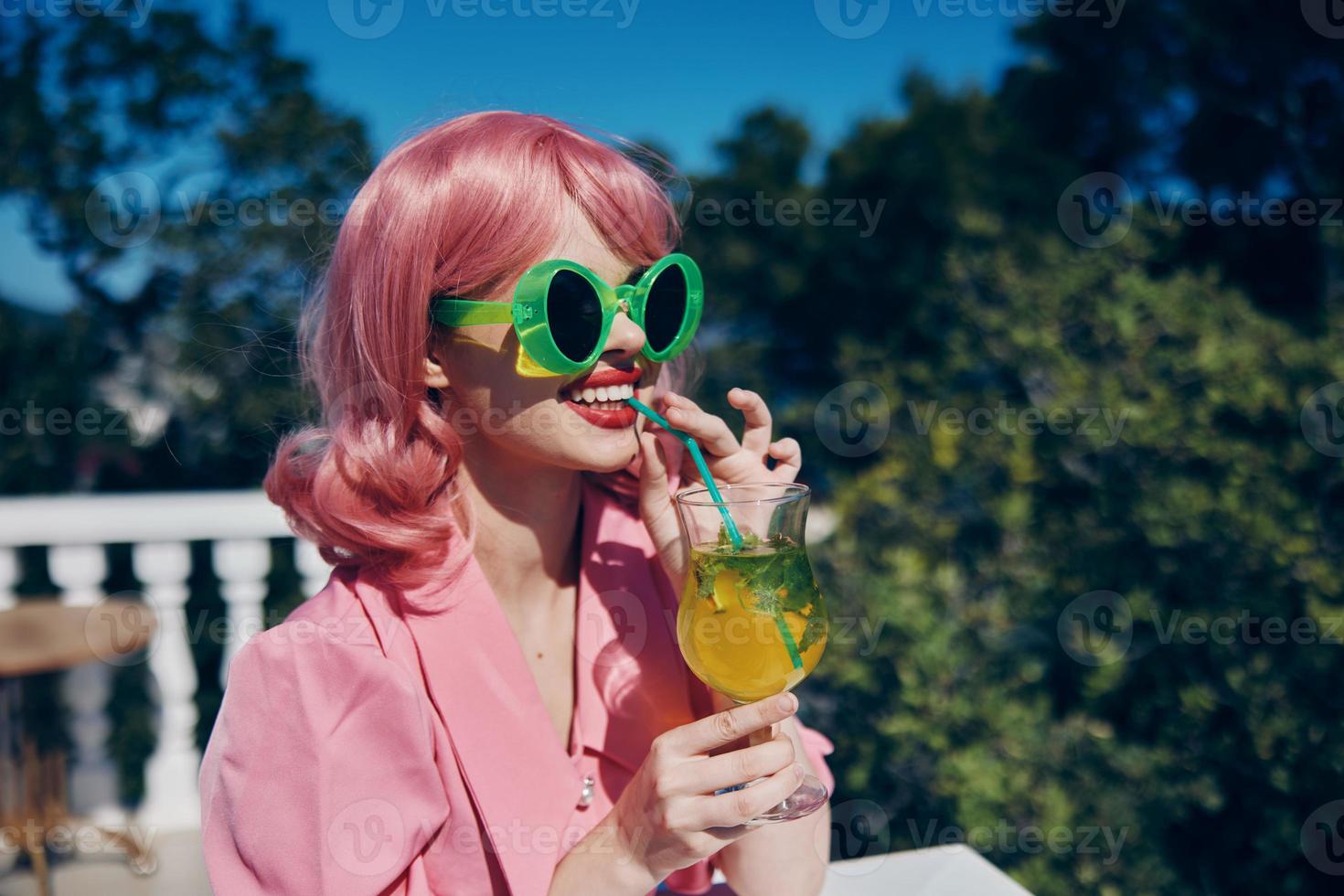 Young female in pink dress outdoors with cocktail Relaxation concept photo