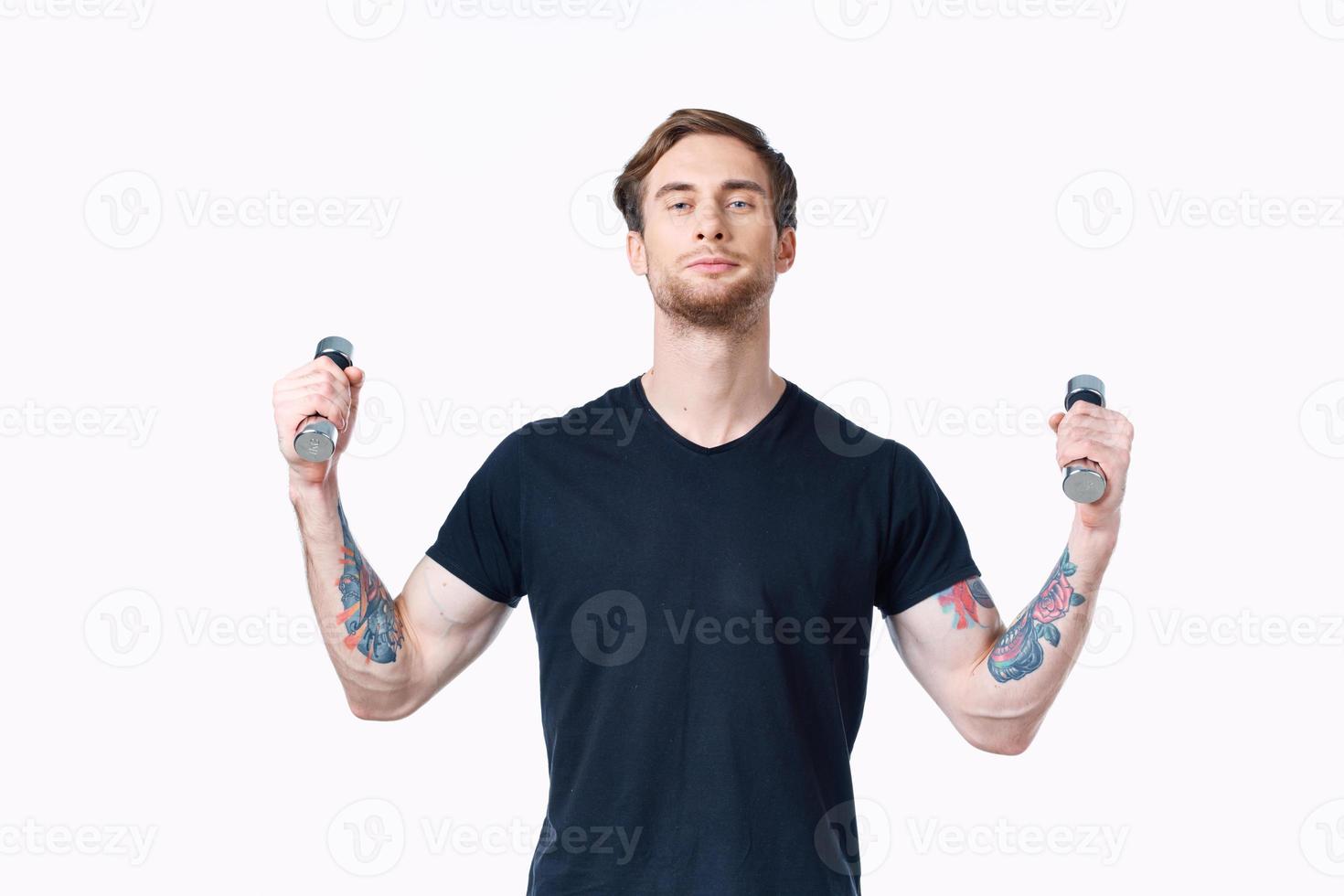 man with dumbbells in his hands Sport Fitness tattoo on his arm and white background photo