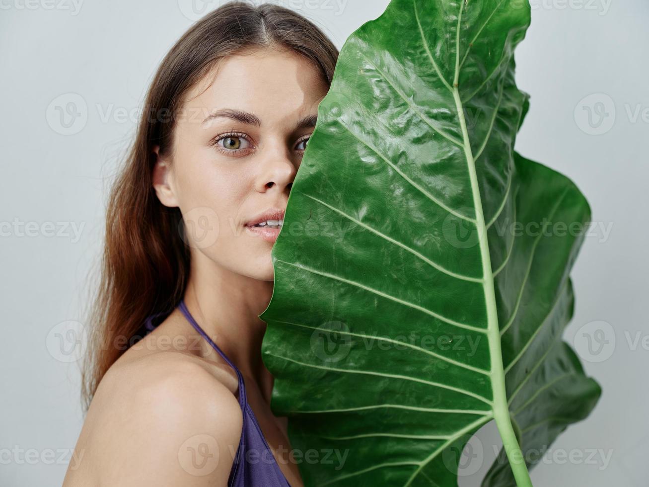 bonito mujer verde palma hoja cerca cara desnudo espalda claro piel zona tropical foto