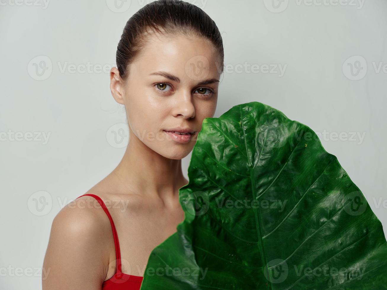 dermatología hermosa mujer con palma hoja y rojo camiseta foto