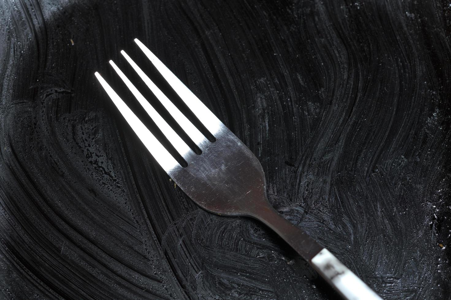 Black dirty plate with fork photo