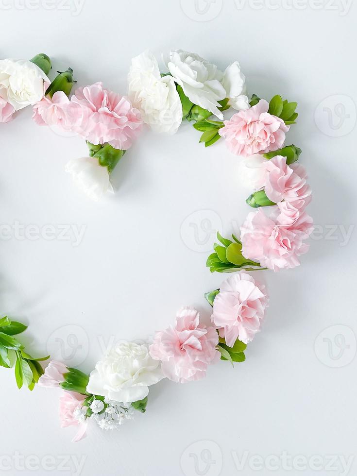 Frame in form of heart from pink, white carnations photo