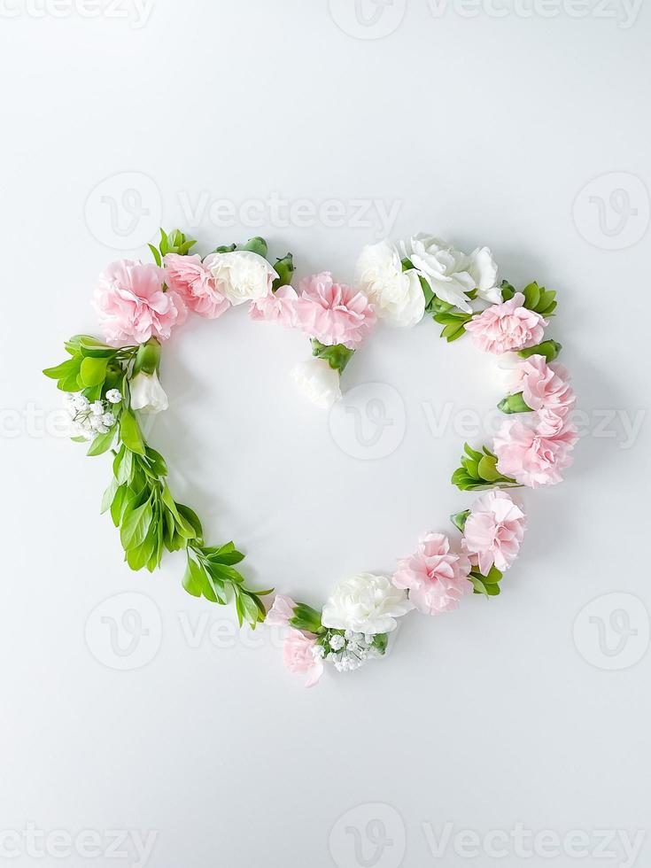 Frame in form of heart from pink, white carnations photo