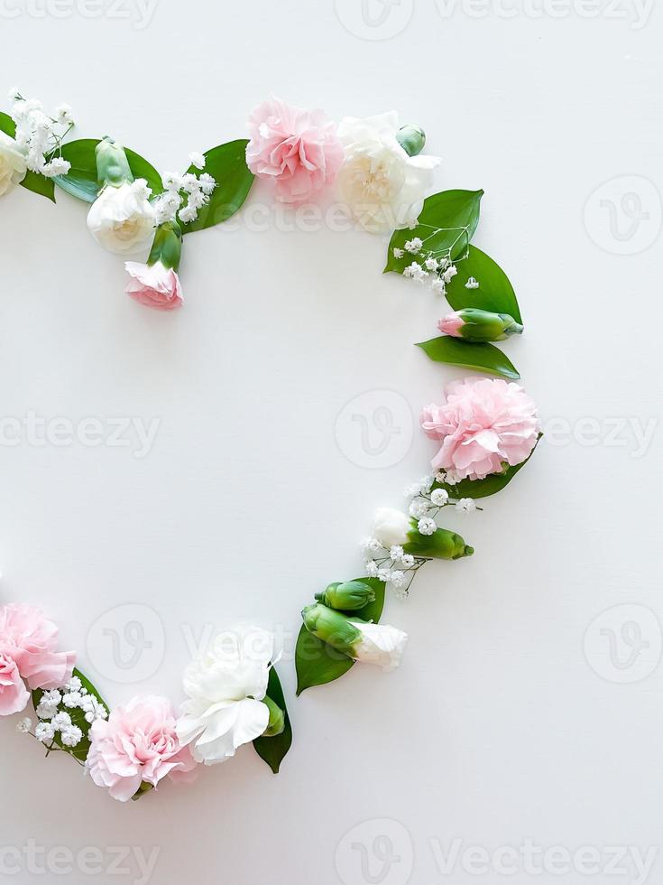 Frame in form of heart from pink, white carnations photo