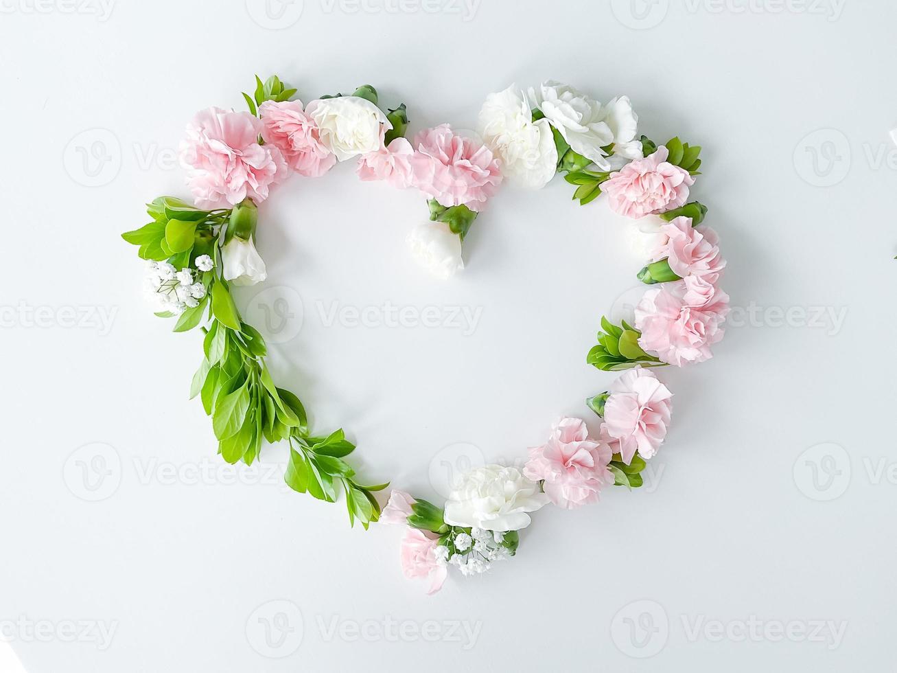 Frame in form of heart from pink, white carnations photo