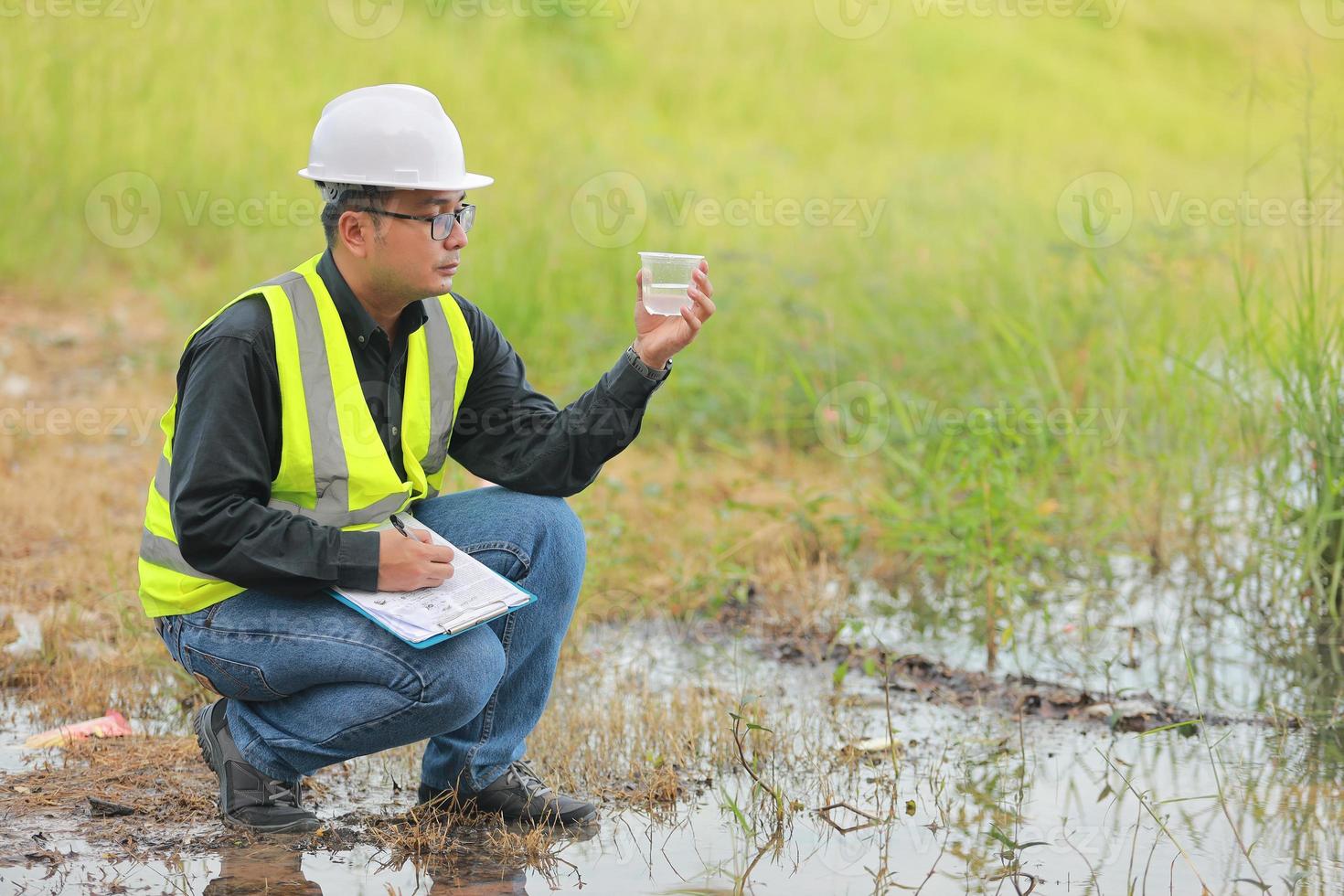 Environmental engineers work at water source to check for contaminants  in water sources and analysing water test results for reuse.World environment day concept. photo