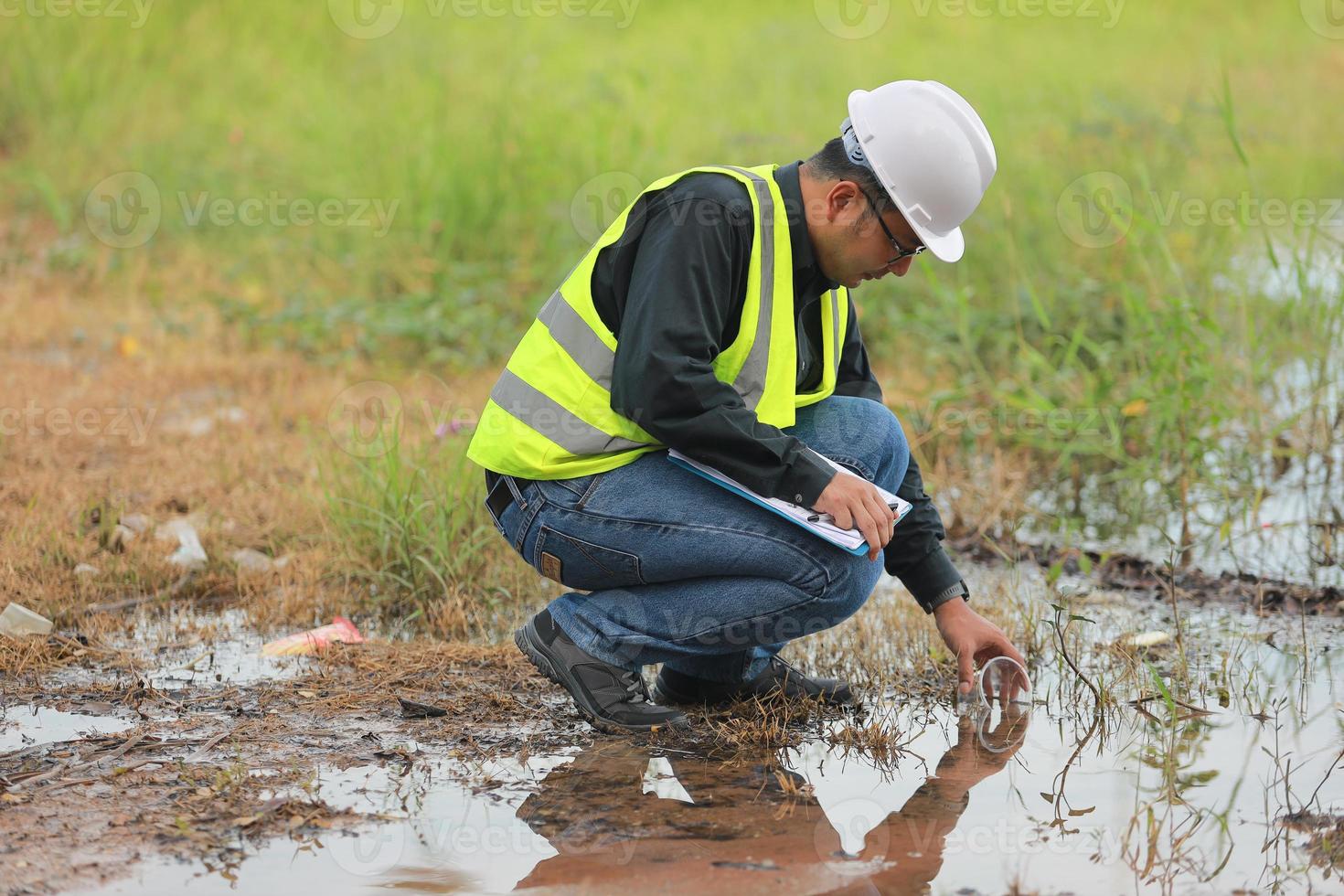 Environmental engineers work at water source to check for contaminants  in water sources and analysing water test results for reuse.World environment day concept. photo