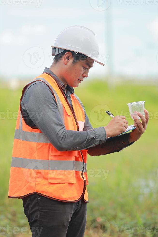Environmental engineers work at water source to check for contaminants  in water sources and analysing water test results for reuse.World environment day concept. photo