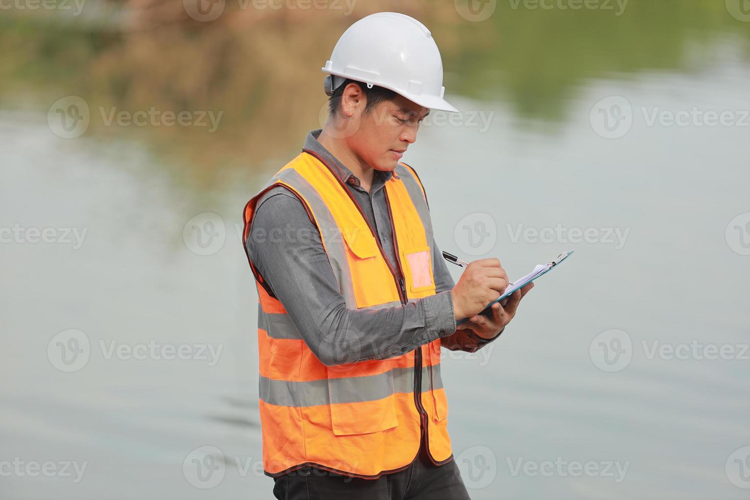 Environmental engineers work at water source to check for contaminants  in water sources and analysing water test results for reuse.World environment day concept. photo