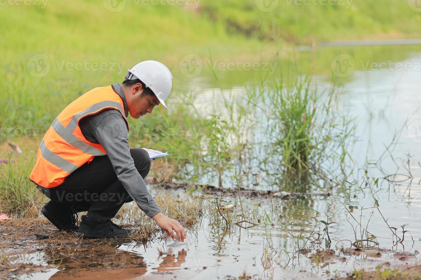 Environmental engineers work at water source to check for contaminants  in water sources and analysing water test results for reuse.World environment day concept. photo