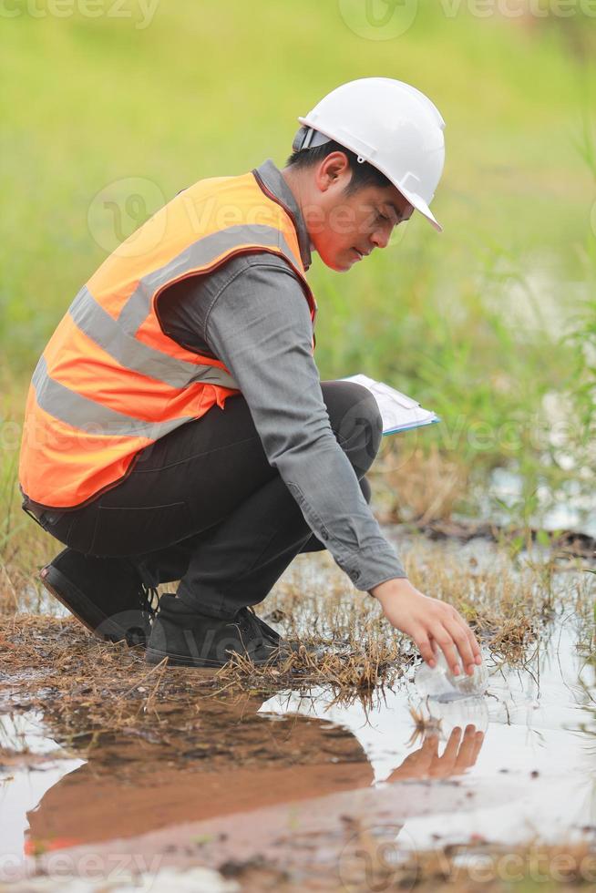 Environmental engineers work at water source to check for contaminants  in water sources and analysing water test results for reuse.World environment day concept. photo