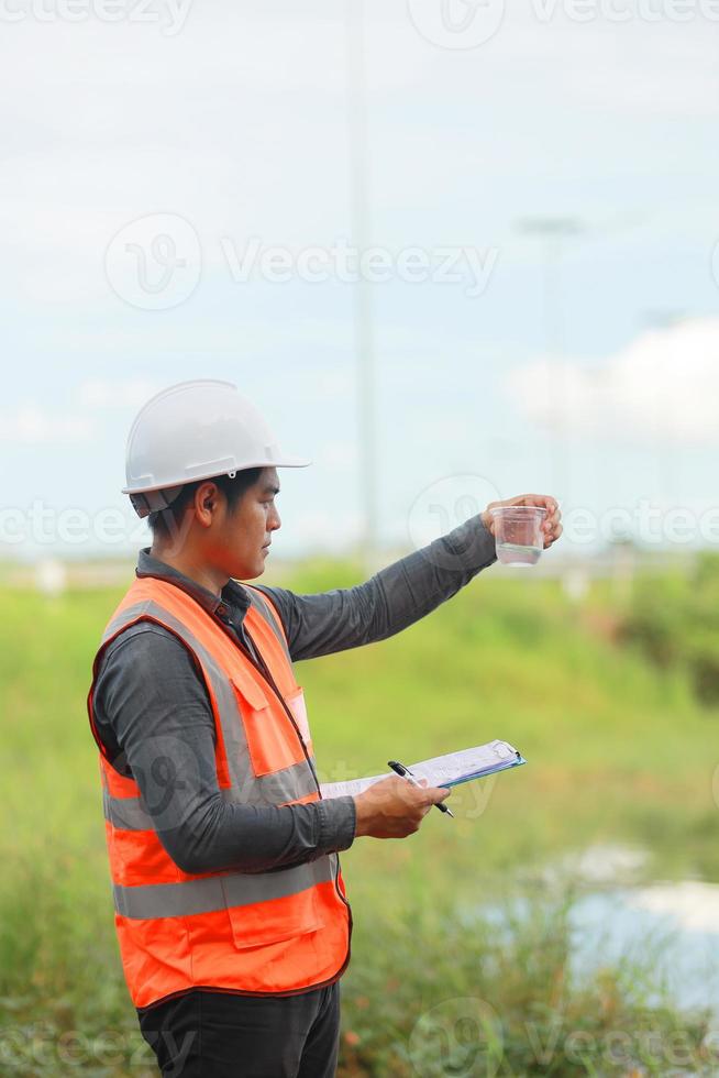 Environmental engineers work at water source to check for contaminants  in water sources and analysing water test results for reuse.World environment day concept. photo