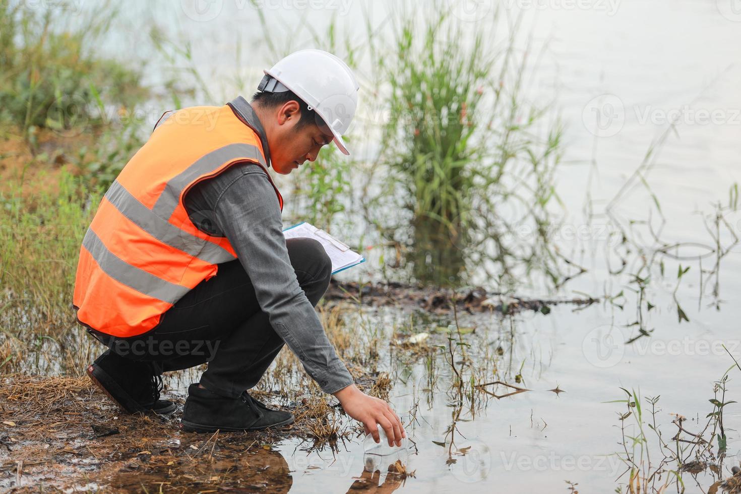 Environmental engineers work at water source to check for contaminants  in water sources and analysing water test results for reuse.World environment day concept. photo