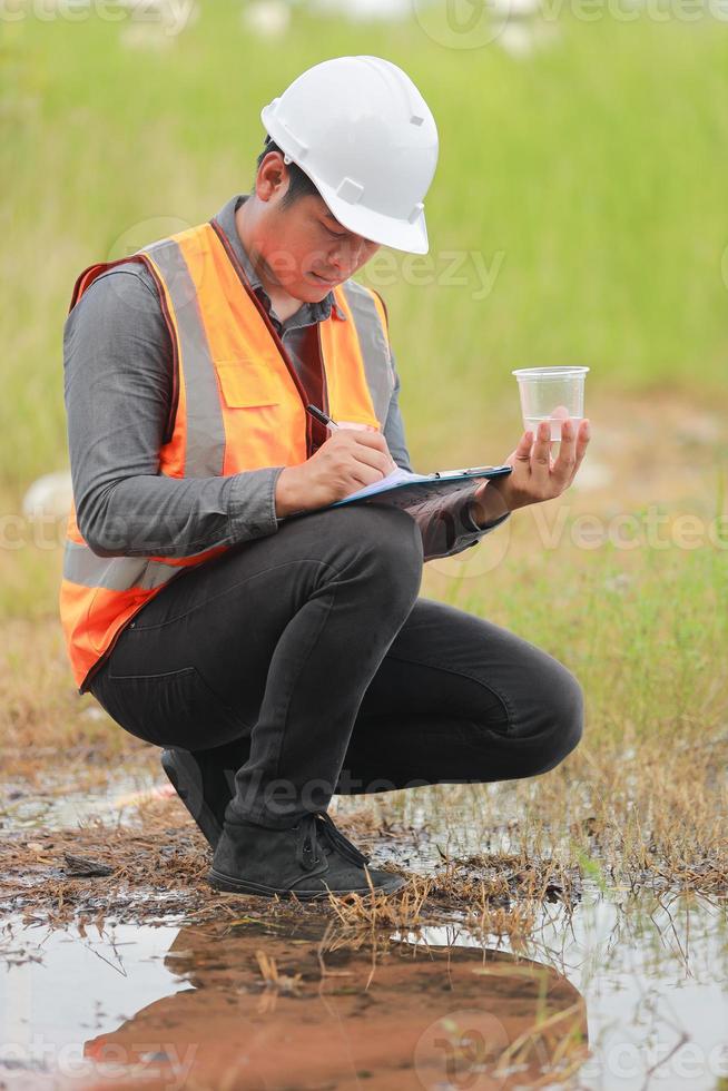 Environmental engineers work at water source to check for contaminants  in water sources and analysing water test results for reuse.World environment day concept. photo
