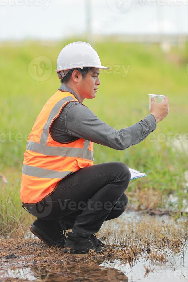 Environmental engineers work at water source to check for contaminants  in water sources and analysing water test results for reuse.World environment day concept. photo