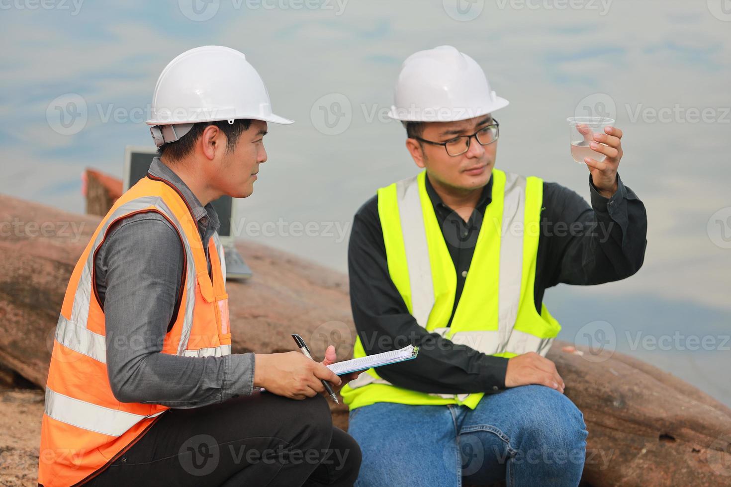 Environmental engineers work at water source to check for contaminants  in water sources and analysing water test results for reuse.World environment day concept. photo