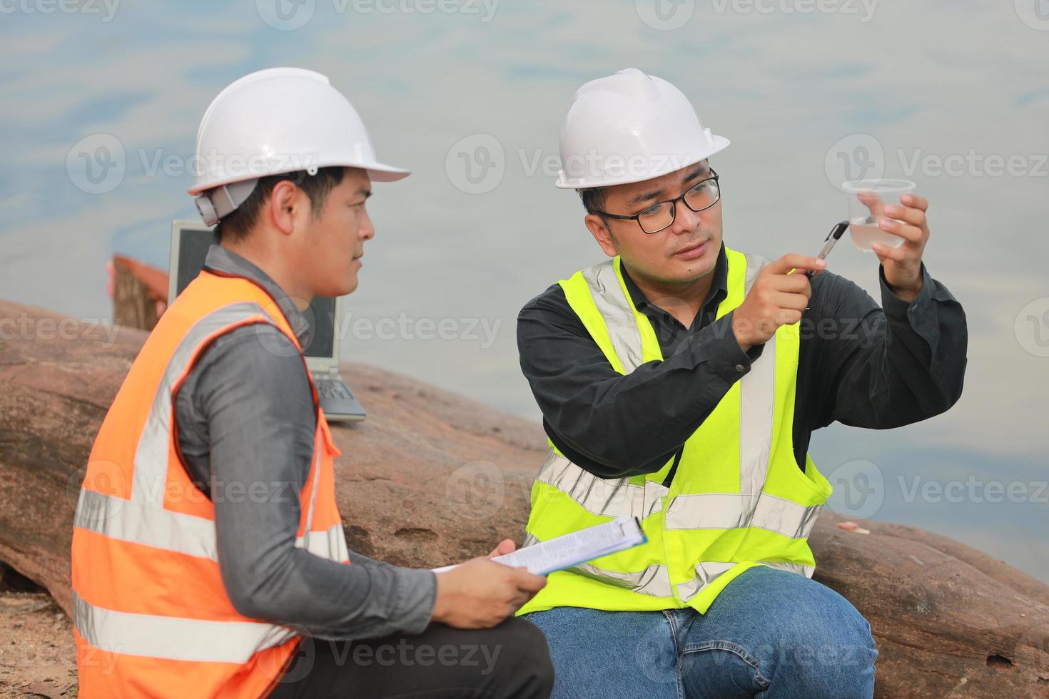 Environmental engineers work at water source to check for contaminants  in water sources and analysing water test results for reuse.World environment day concept. photo