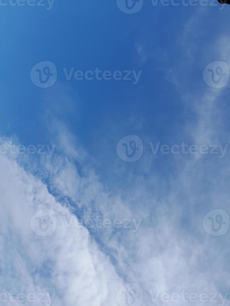 Beautiful white clouds on deep blue sky background. Large bright soft fluffy clouds are cover the entire blue sky. photo