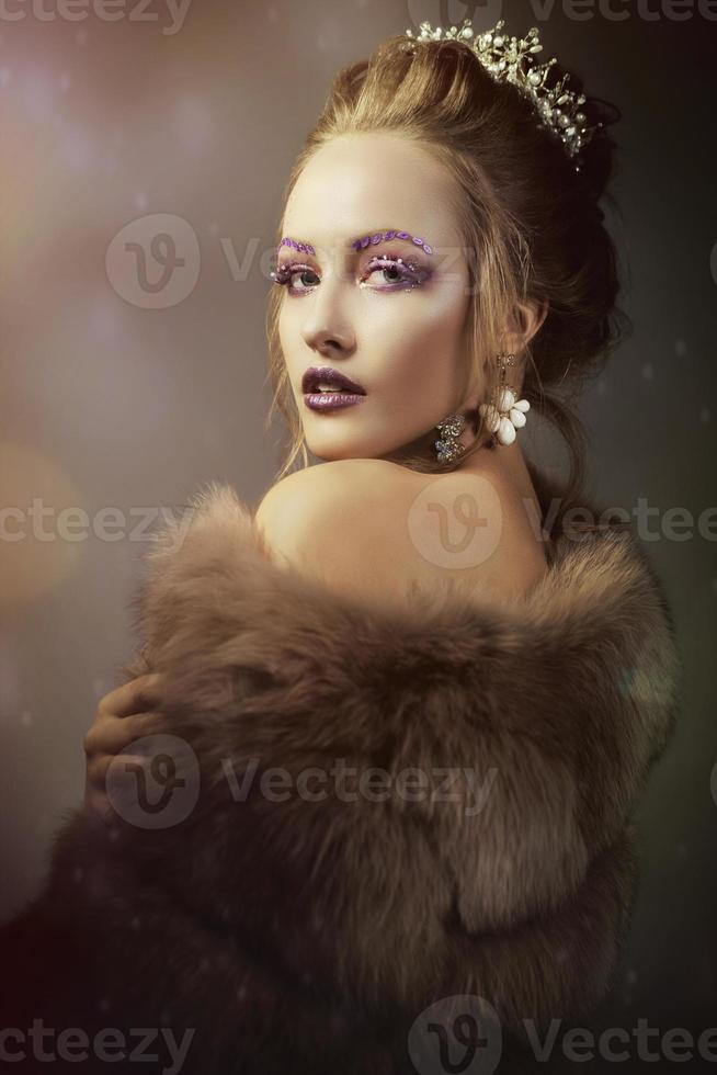 Luxurious girl with a beautiful make-up in a fur coat. Beauty in furs. Model on a bokeh background. Young beautiful woman. photo