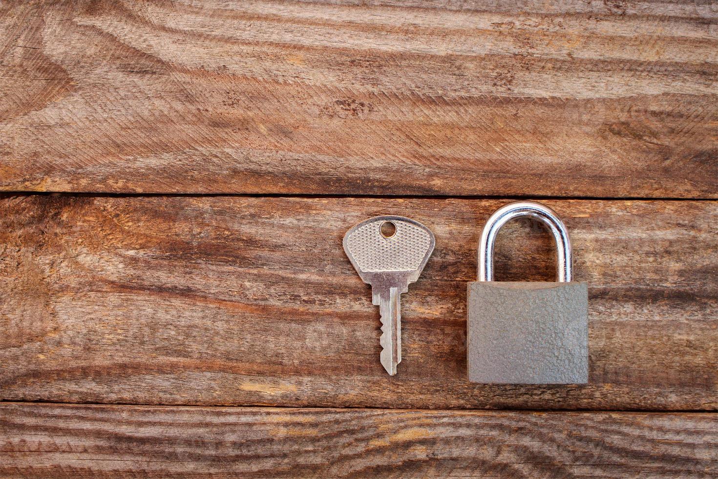 key and lock on wooden background. Toned image. photo