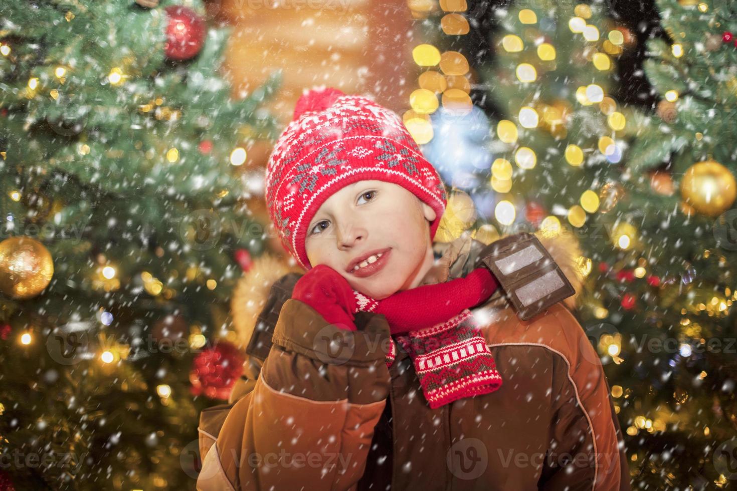 Baby on christmas background. A boy in a red hat on Christmas street. photo