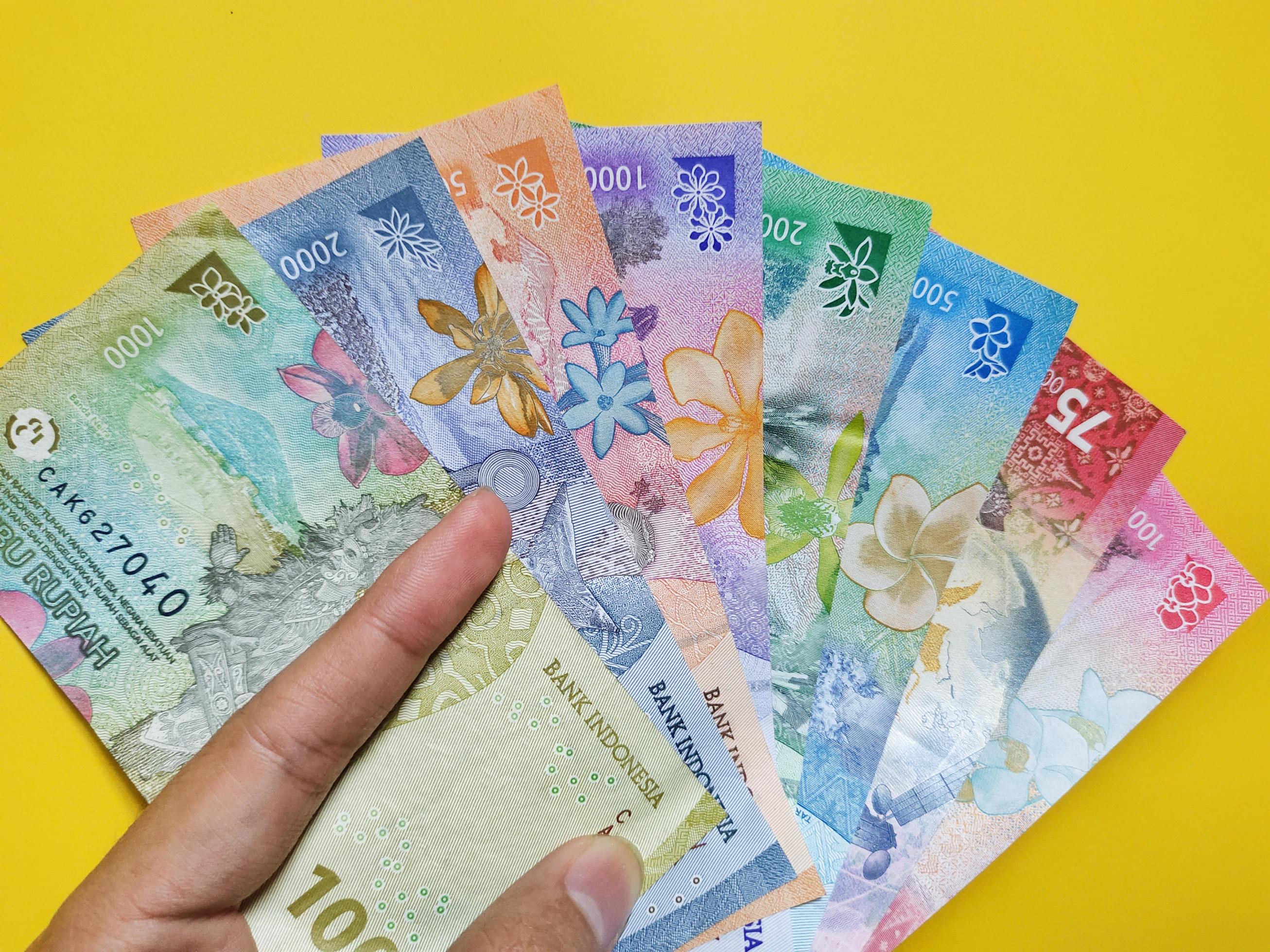 Man Holding New Banknotes Issued In 2022 From Rp 1 000 To Rp 100 000 man-holding-new-banknotes-issued-in-2022-from-rp-1-000-to-rp-100-000