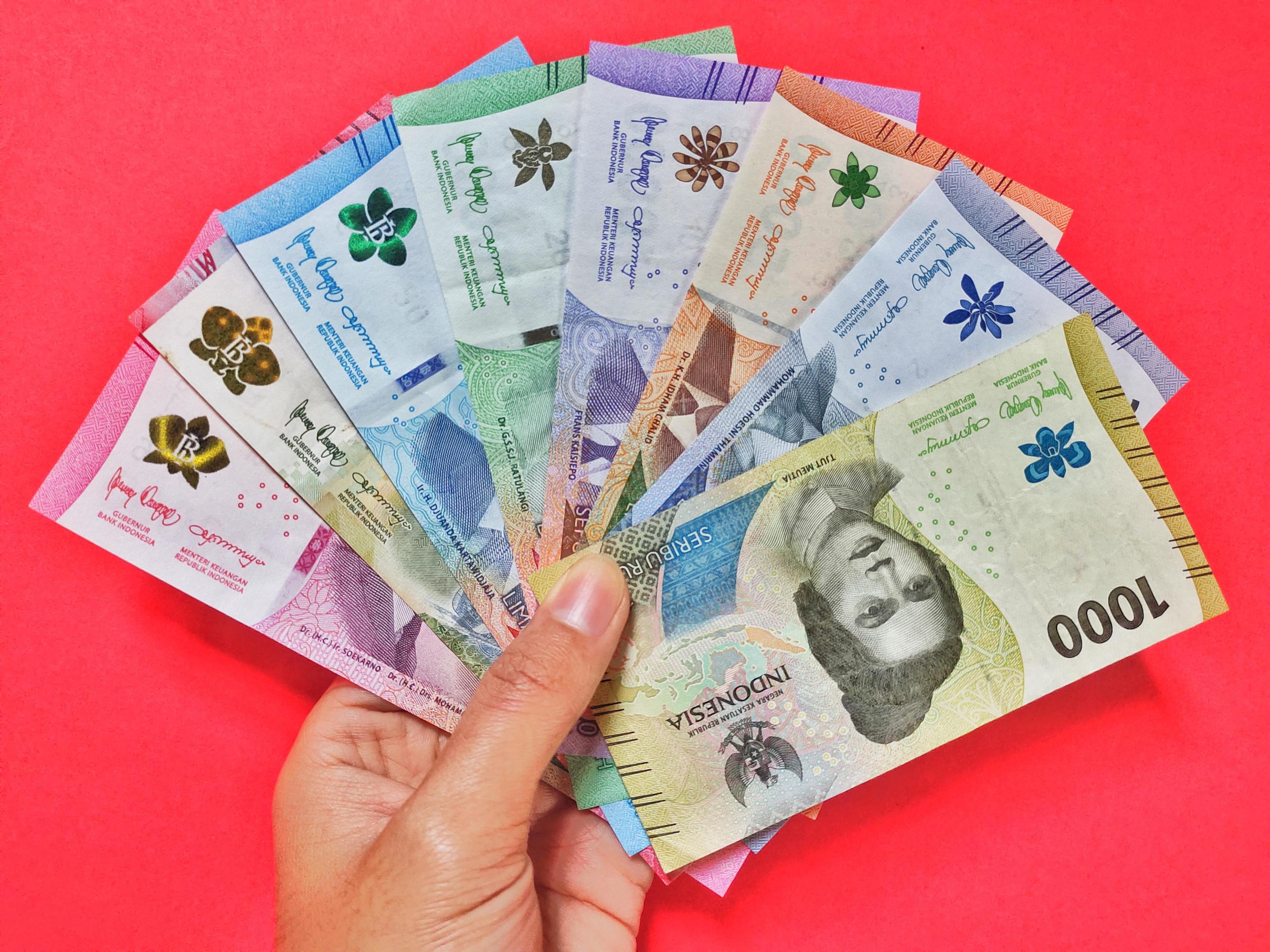 man-holding-new-banknotes-issued-in-2022-from-rp-1-000-to-rp-100-000
