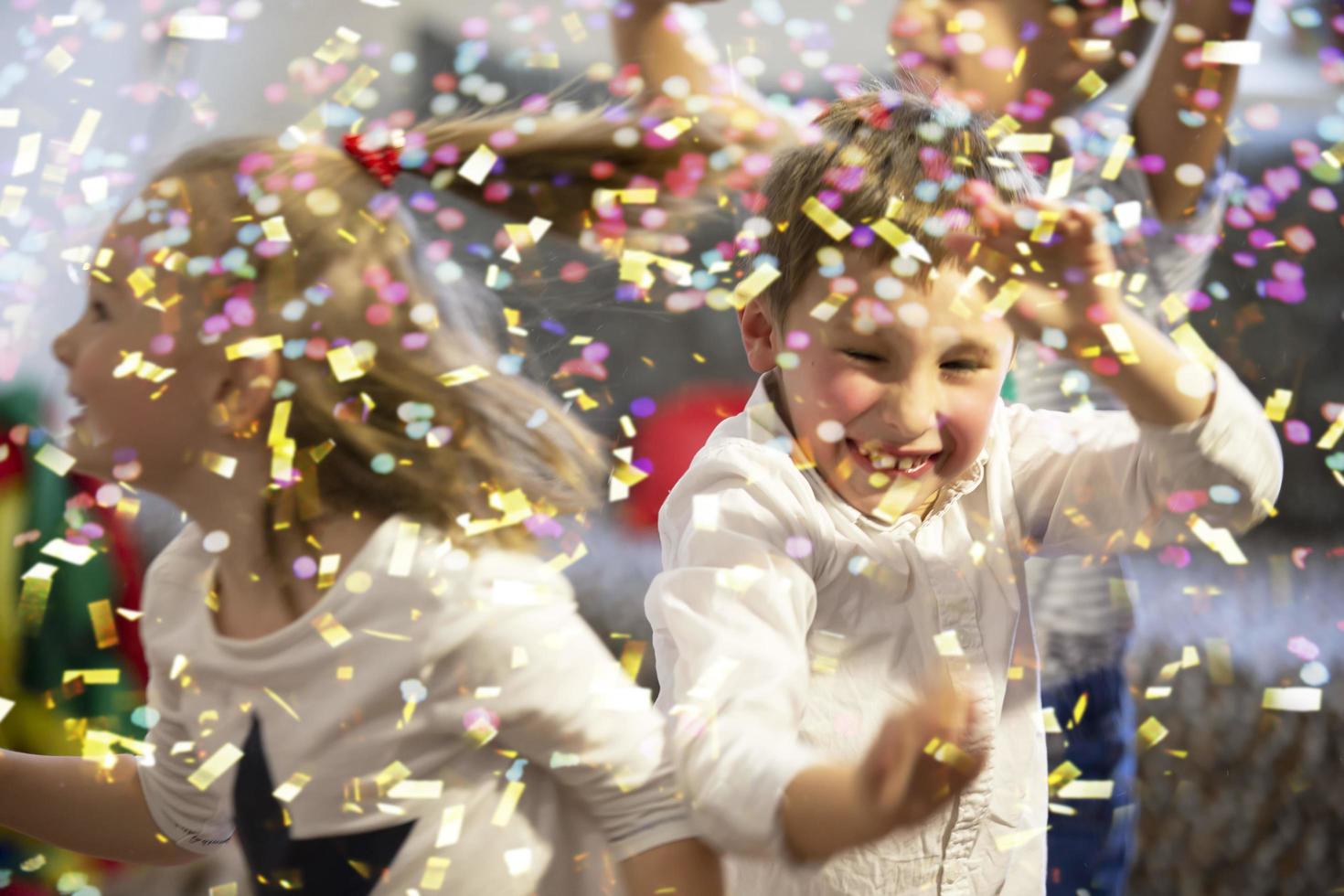 Background party for children. Multicolored confetti on the background of joyful faces. photo