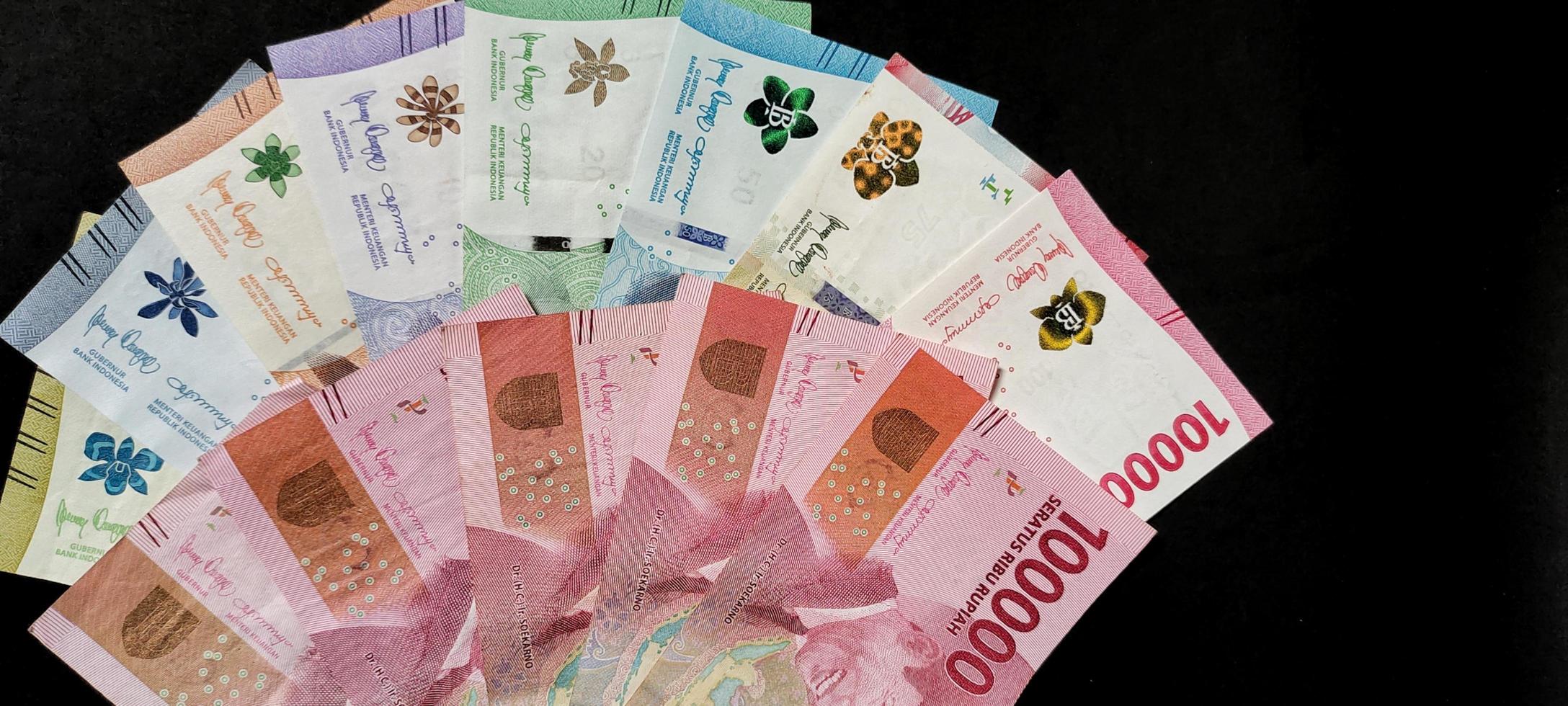 New banknotes issued in 2022 from Rp.1,000 to Rp.100,000. Indonesian rupiah currency concept isolated on black background. Negative space photo