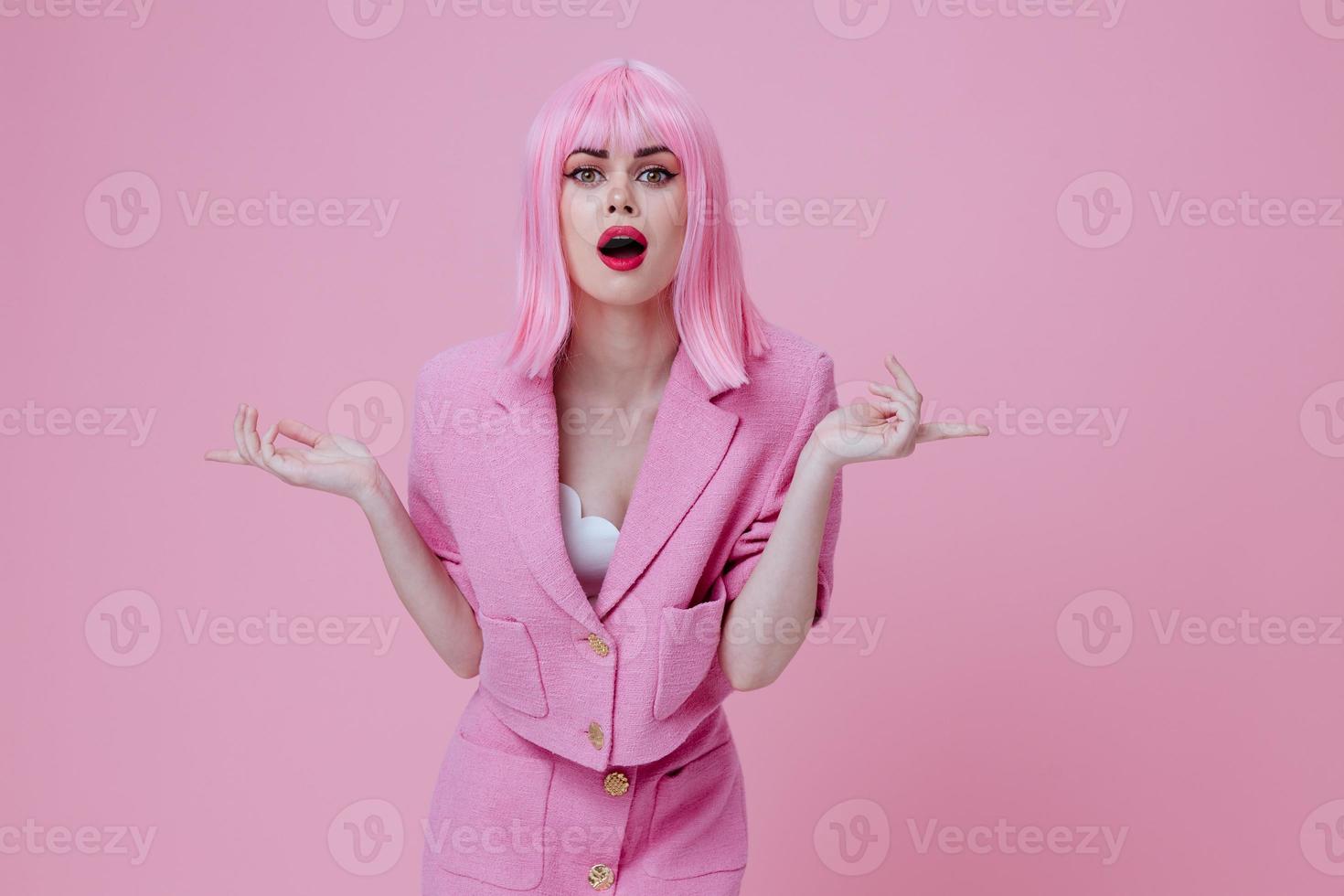 Beautiful fashionable girl gestures with his hands with a pink jacket pink background unaltered photo