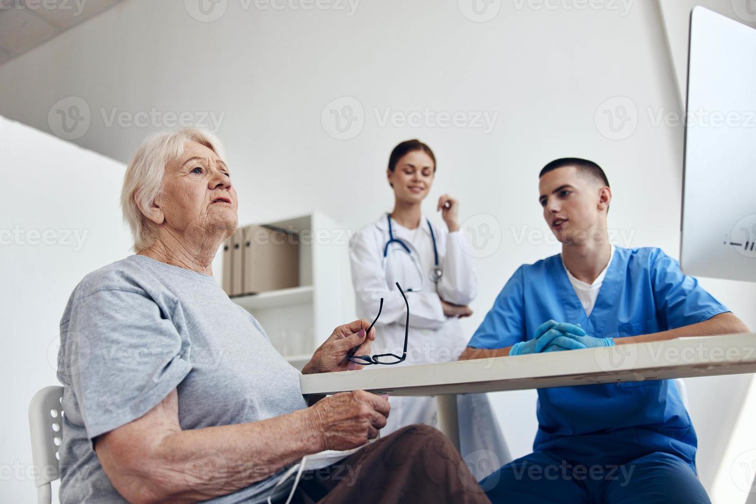 elderly patient at the doctor's and nurse's appointments in the medical office photo