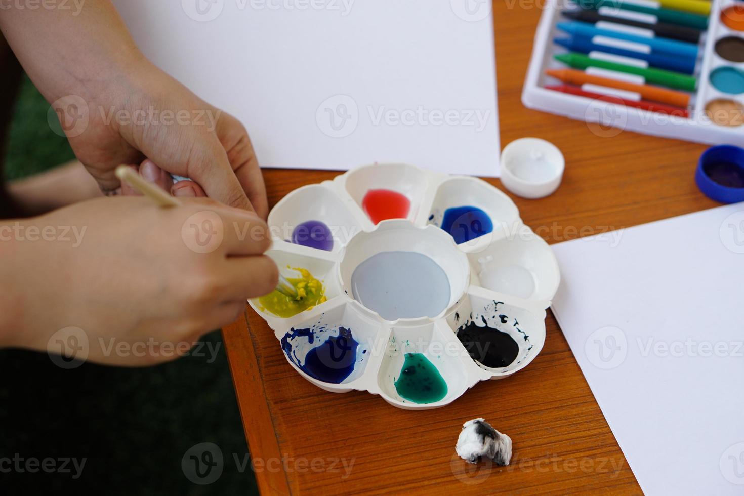 Closeup student is studying art subject, painting, art activity, Mixing color.Concept, Art teaching materials , Education,  fun activity, enhance kids imagination , creativity, concentration and relax photo