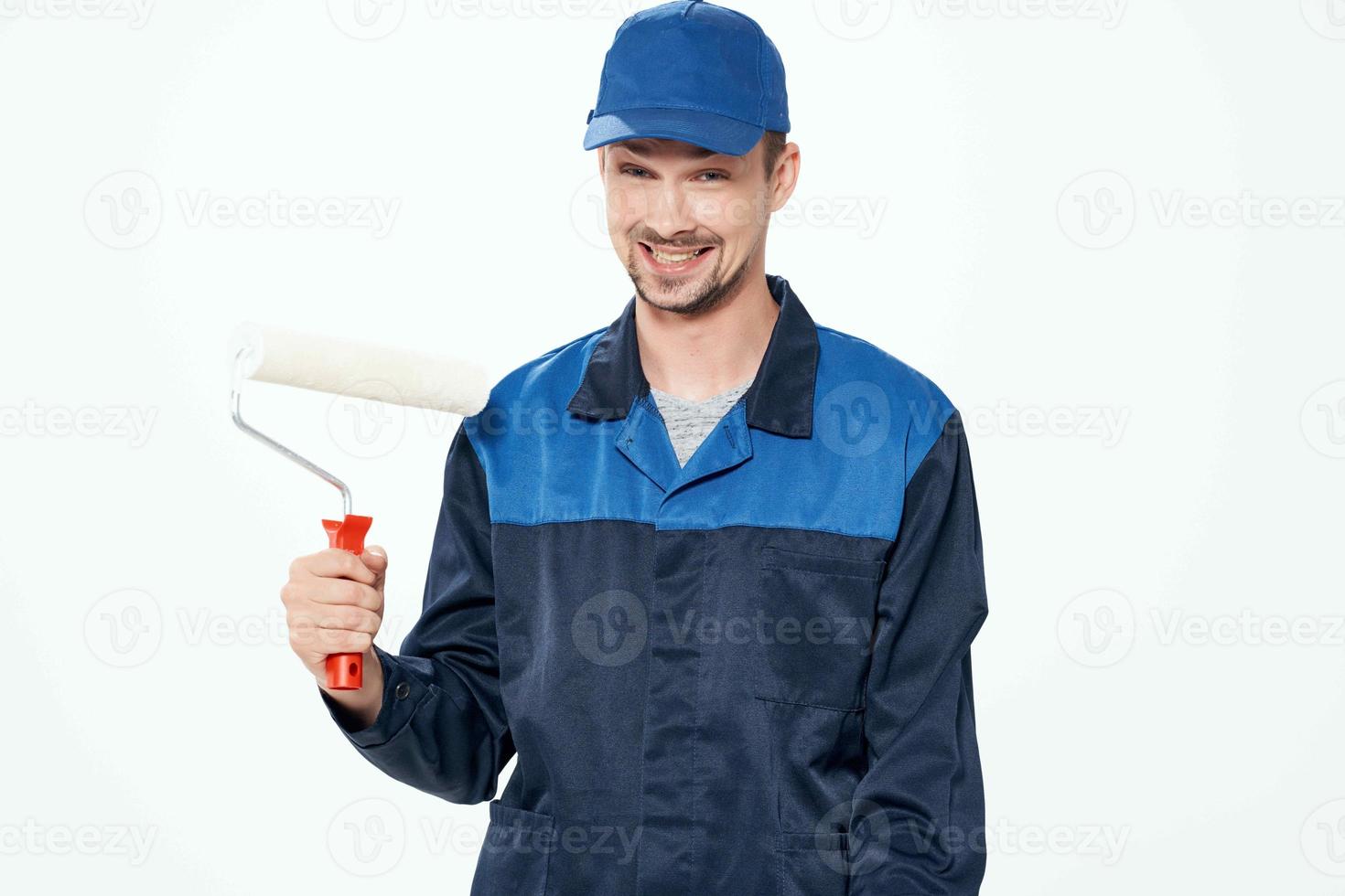 a man in a working uniform painting the walls repairing the house photo