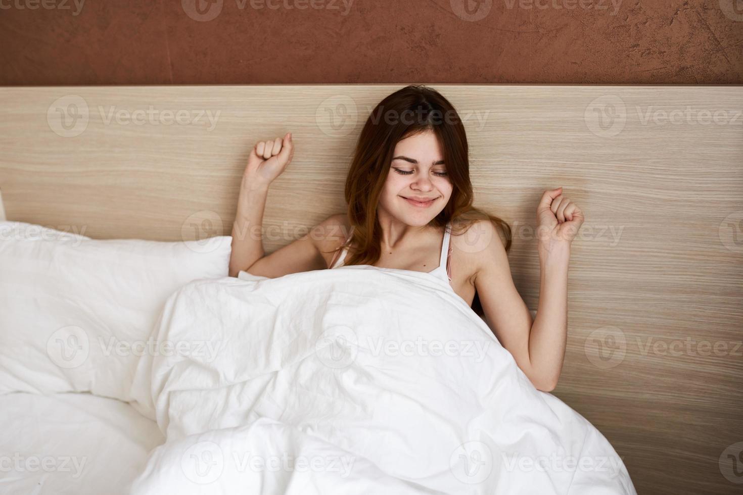 woman woke up in bed under the covers sipping model emotions morning photo