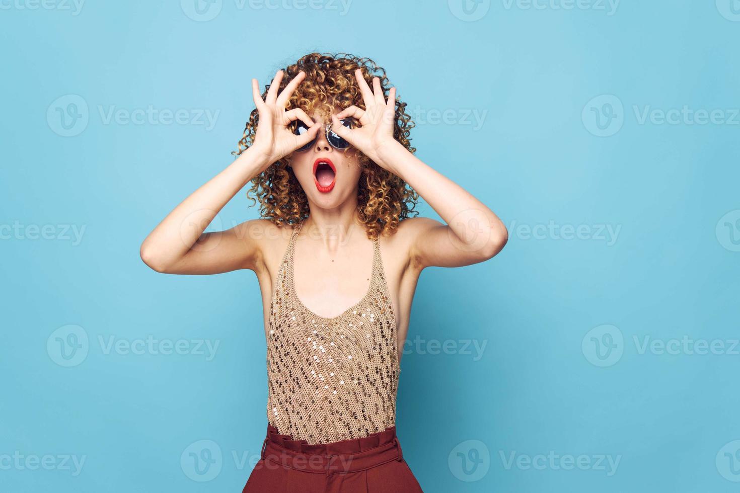 woman Surprise gestures with hands near curly hair face sequin shirt photo