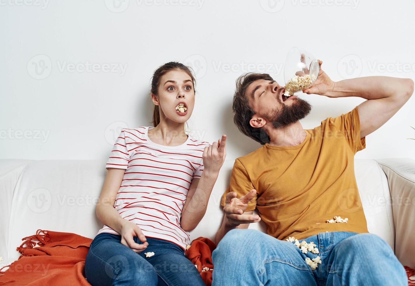 Man eating popcorn and pretty woman in a bright room family friends communicatio photo