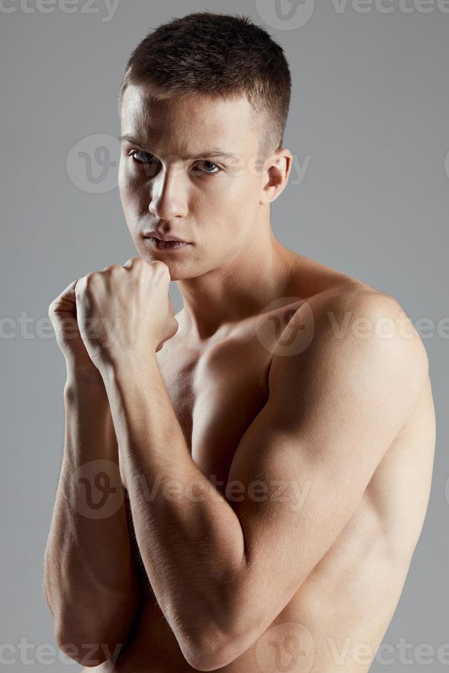 boxer with inflated arm muscles biceps Sport Fitness gray background cropped view photo