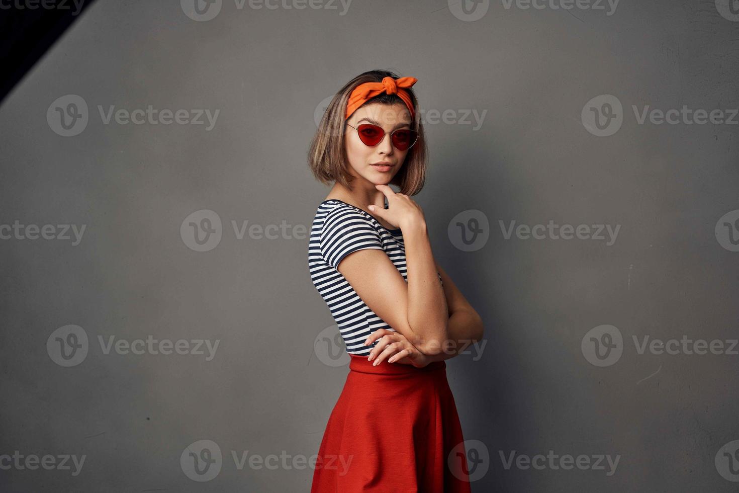 bonito mujer en a rayas camiseta rojo falda posando Moda verano estilo foto