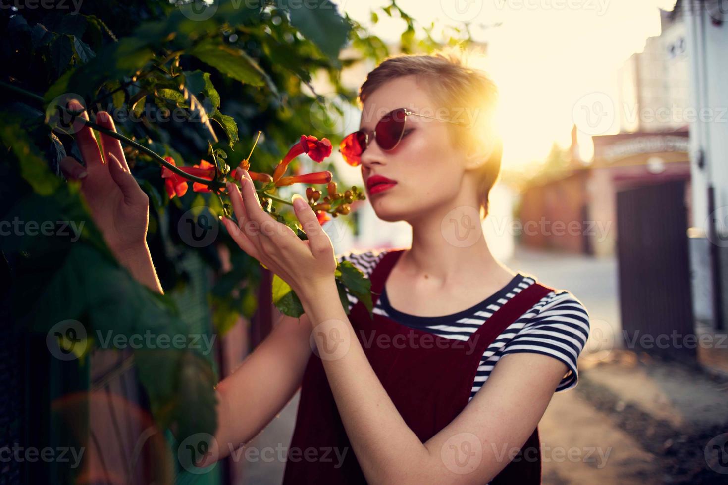 woman in sunglasses on the street near flowers posing lifestyle photo