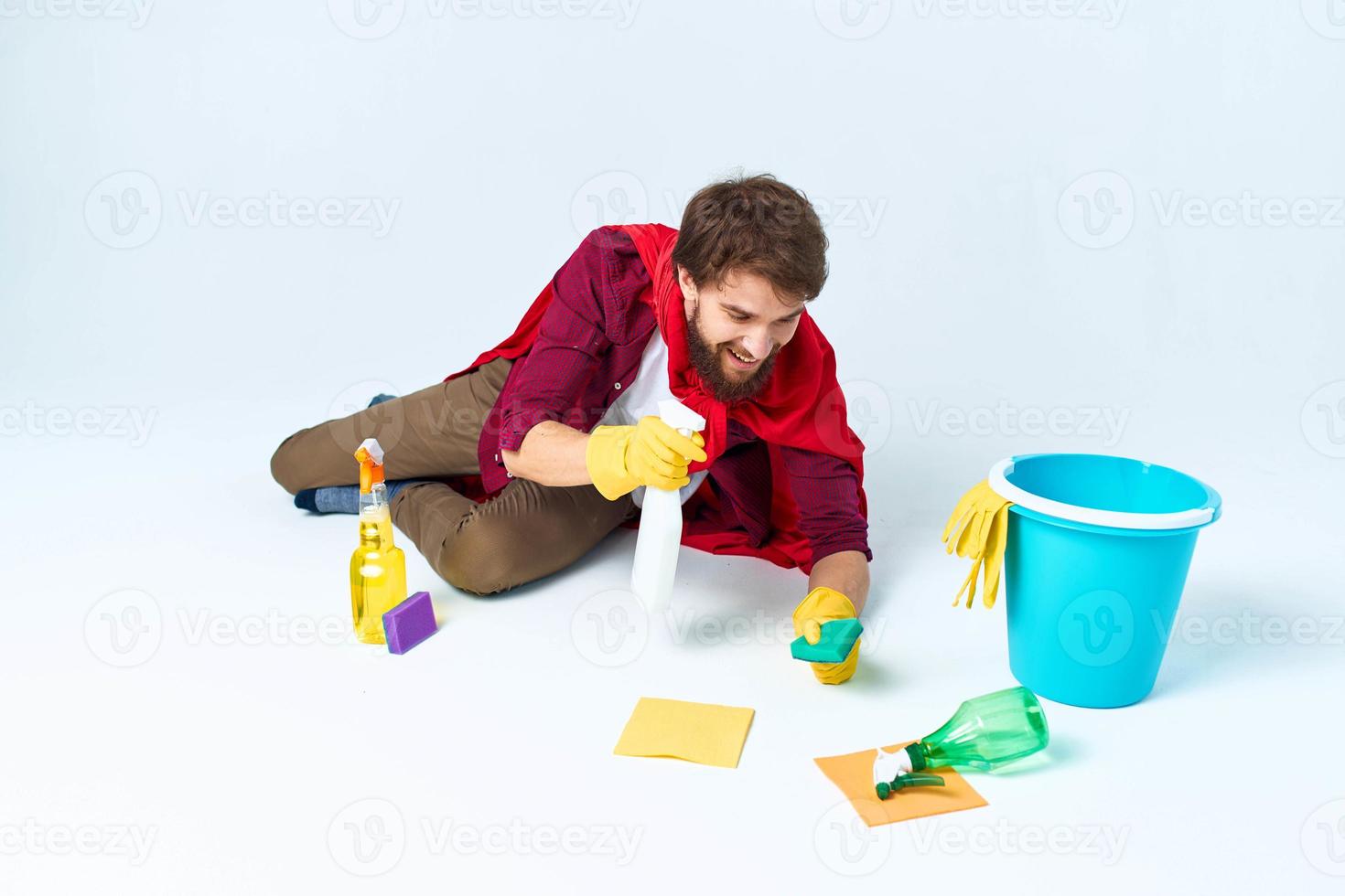 cleaner with cleaning supplies in a red raincoat on the floor of the house interior photo