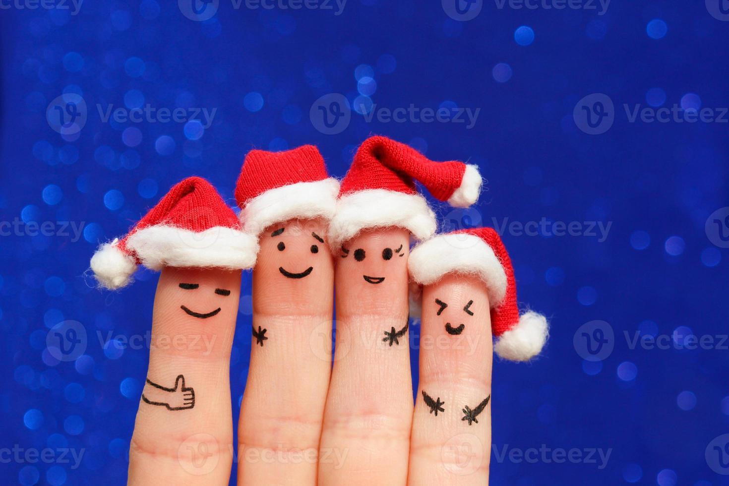 Finger art of friends celebrates Christmas. The concept of a group of people laughing in new year hats. Toned image. photo