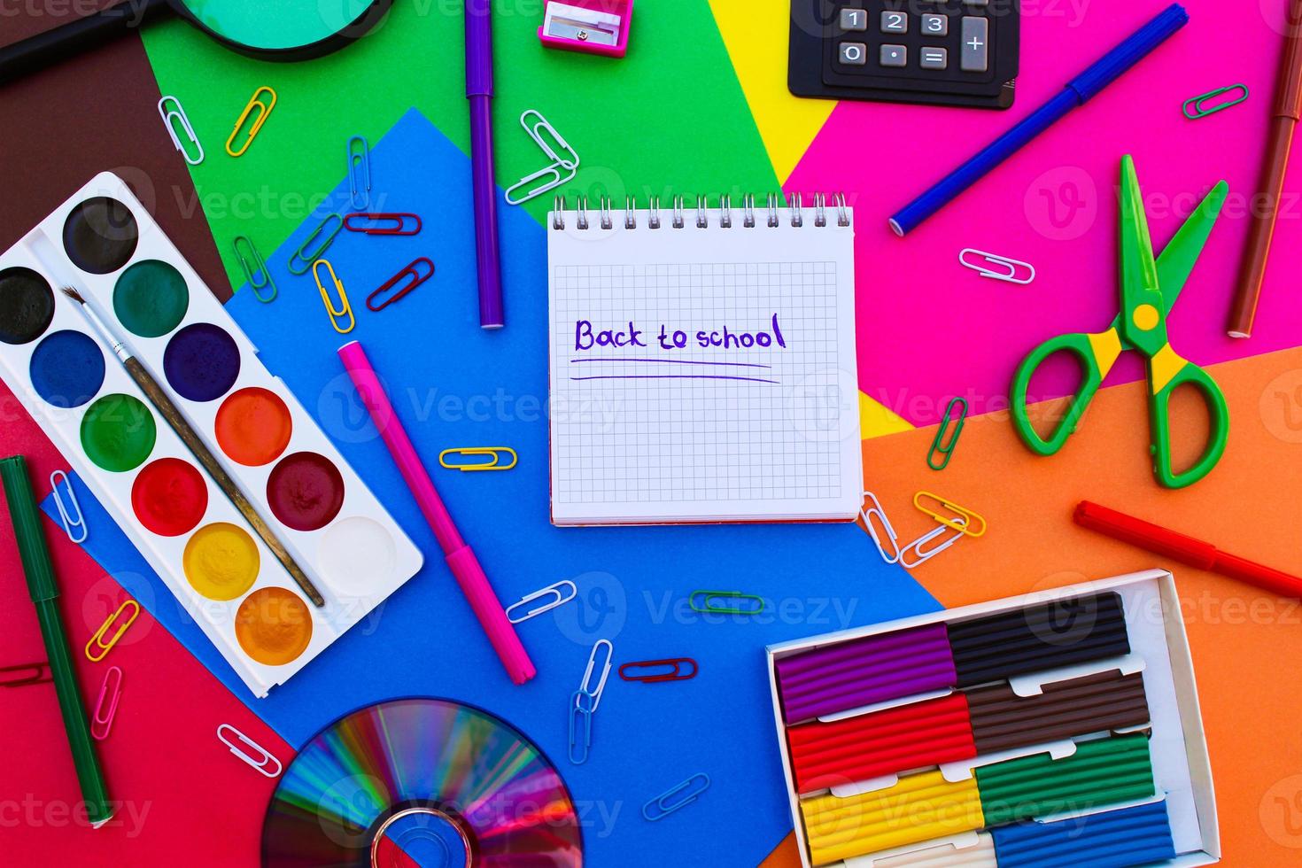 papelería objetos. oficina y colegio suministros en el mesa. subtítulo espalda a escuela. foto