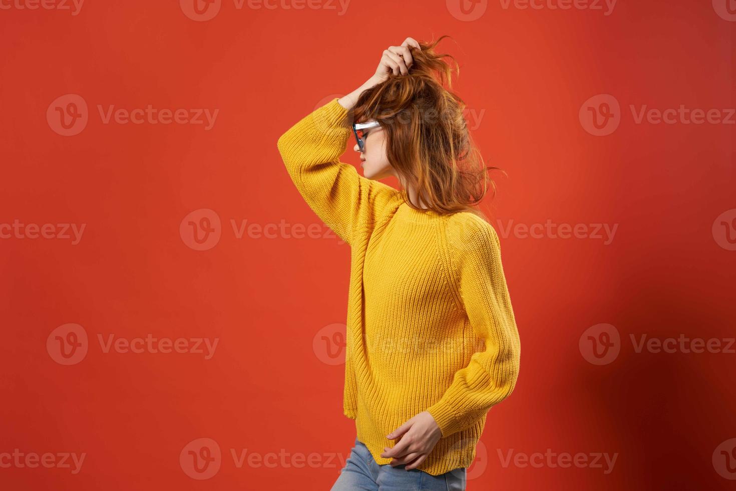 pretty woman in yellow sweater fashion glasses red background photo