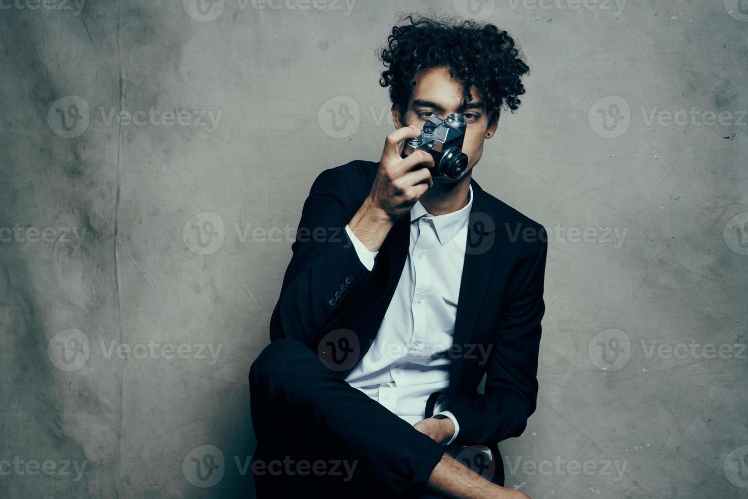 guy in a classic suit with a camera on a fabric background hobby photo