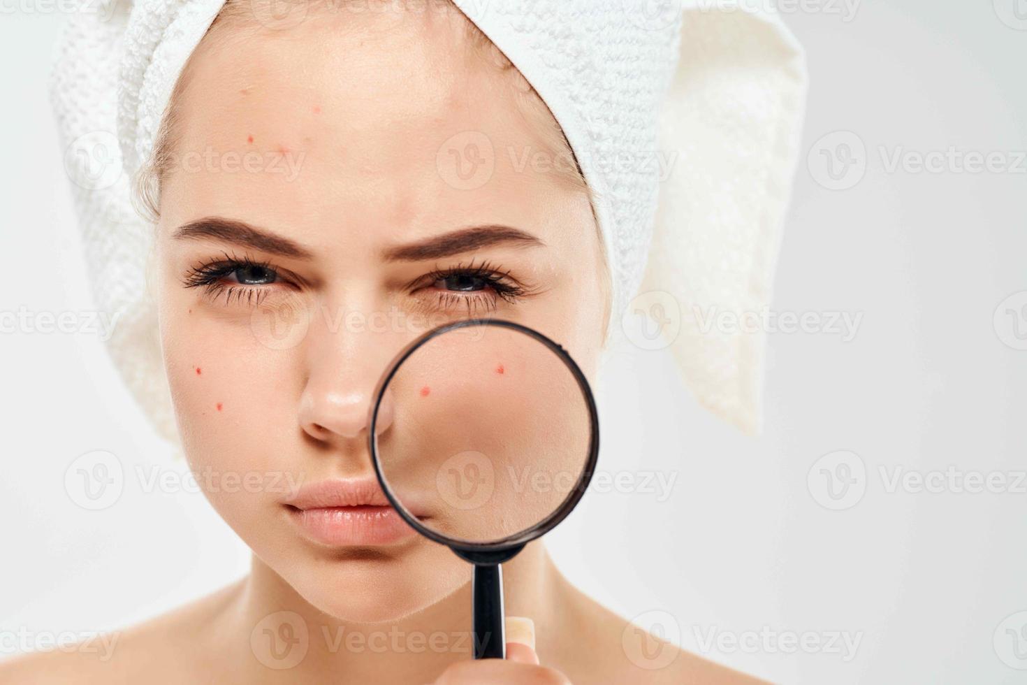 woman holding behold face loupe dermatology close-up clean skin photo