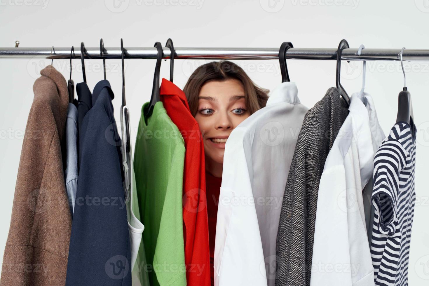 pretty woman next to clothes fashion fun retail light background photo