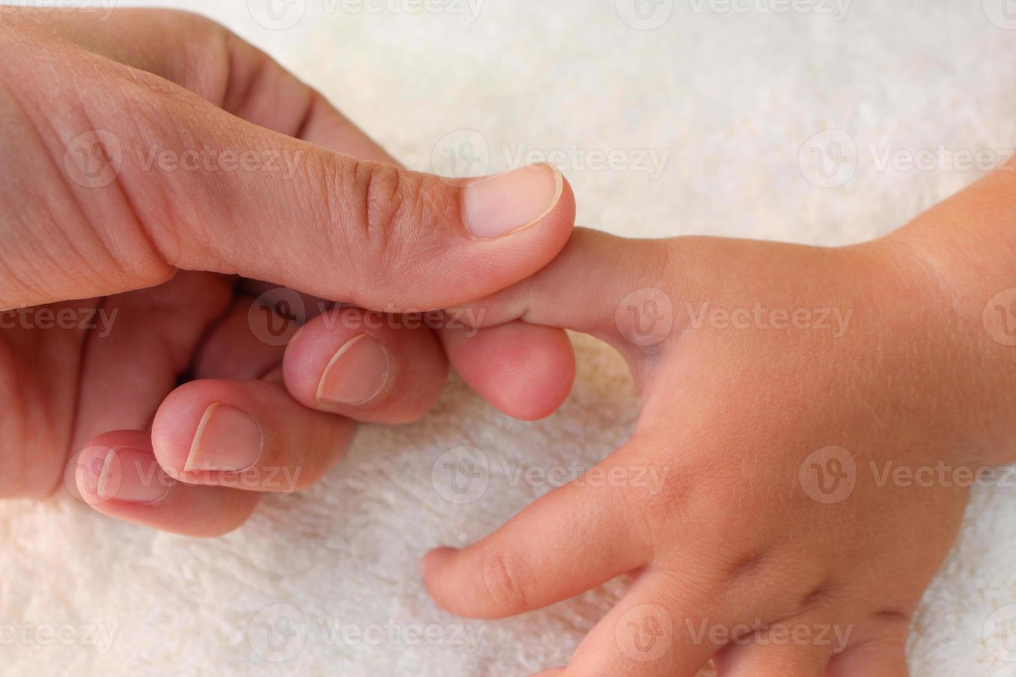 masajista haciendo masaje dedos pequeño bebé. foto