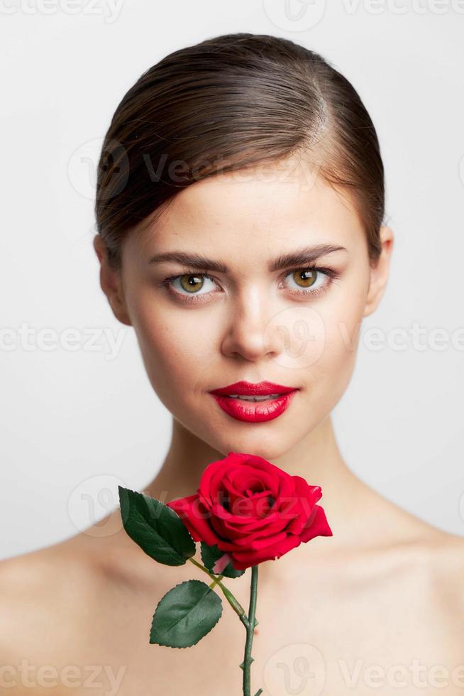 mujer con desnudo espalda con un flor en su manos, un encanto modelo rojo labios foto