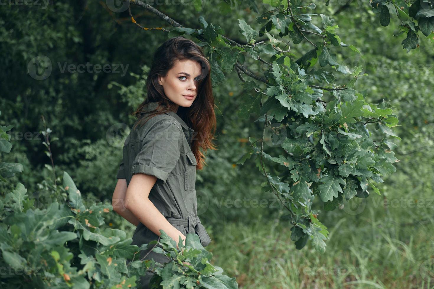 retrato de un mujer verde mono manos en bolsillos en un antecedentes foto